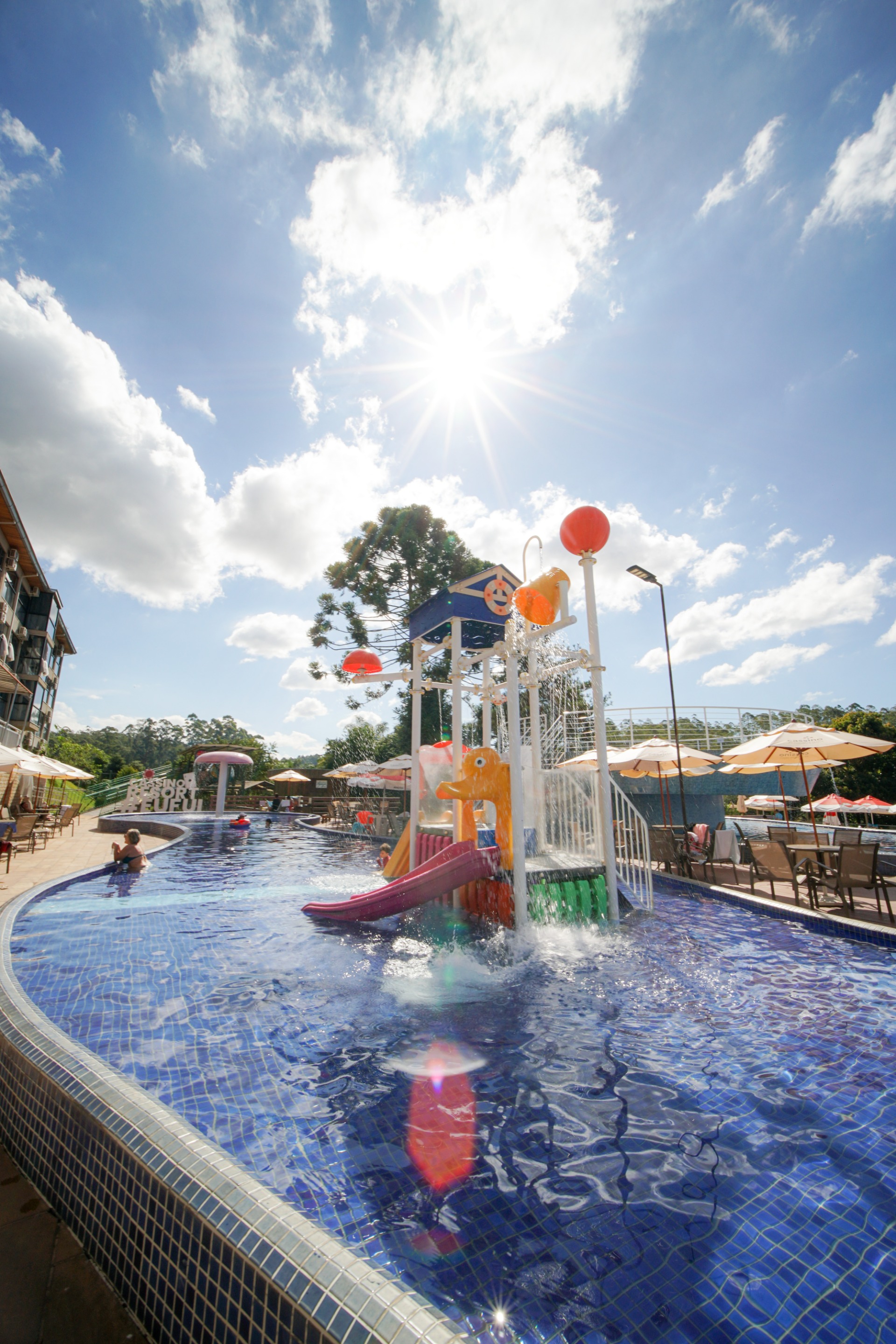 Piscina com brinquedos aquáticos do Cassino Resort em dia de sol