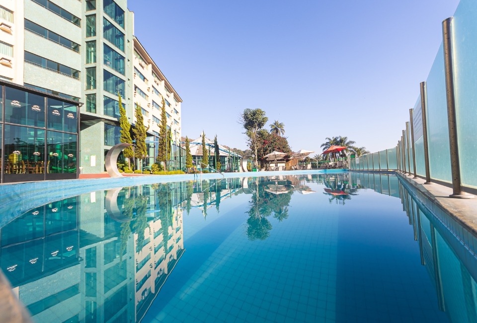 Piscina de borda com o prédio do Thermas Resort refletido na água