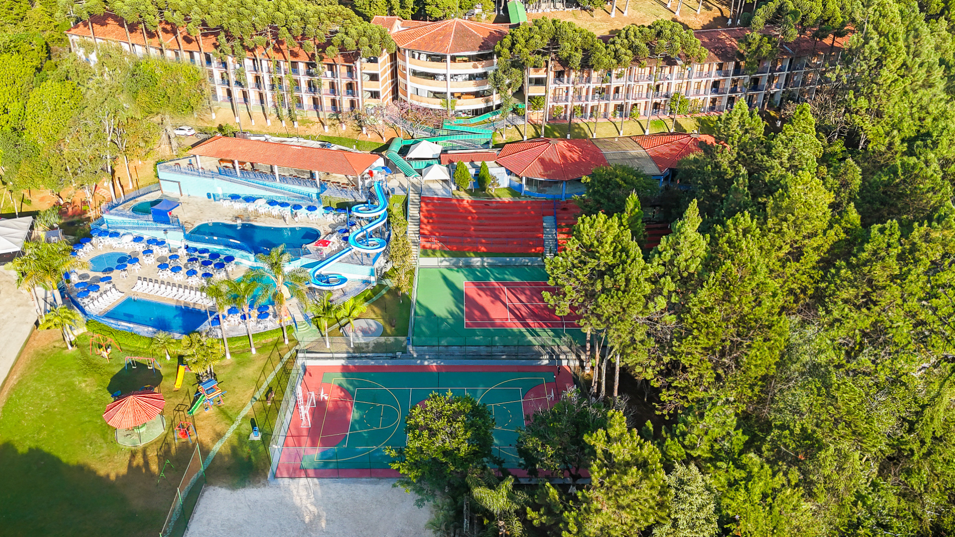 Vista aérea do Village Inn Poços de Caldas, com piscinas, quadras e mata ao redor
